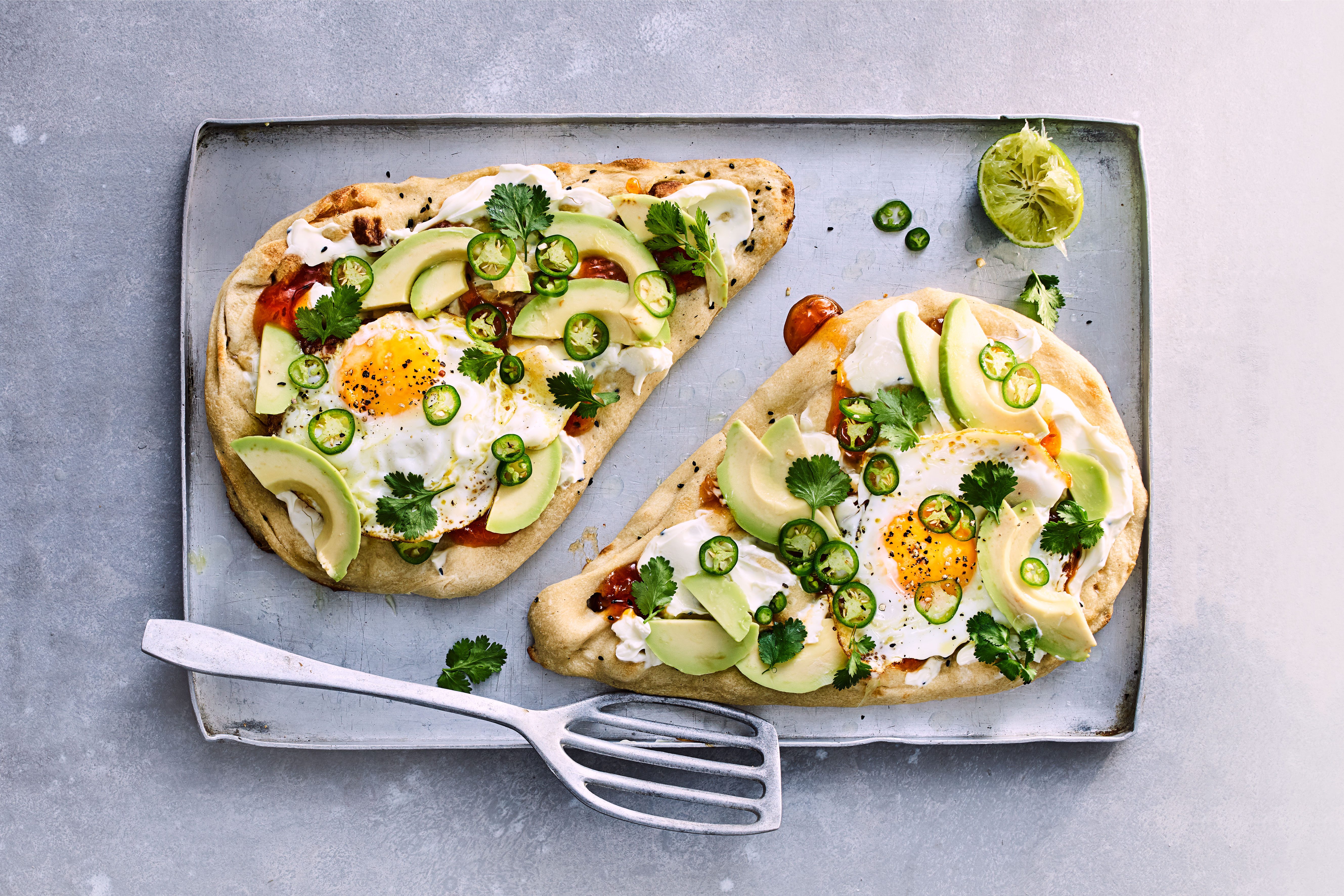 Breakfast naan on a baking tray with a fish slice