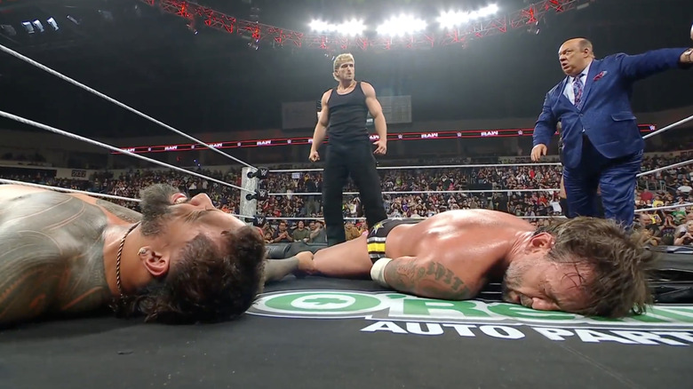 Paul standing over Jey and Punk