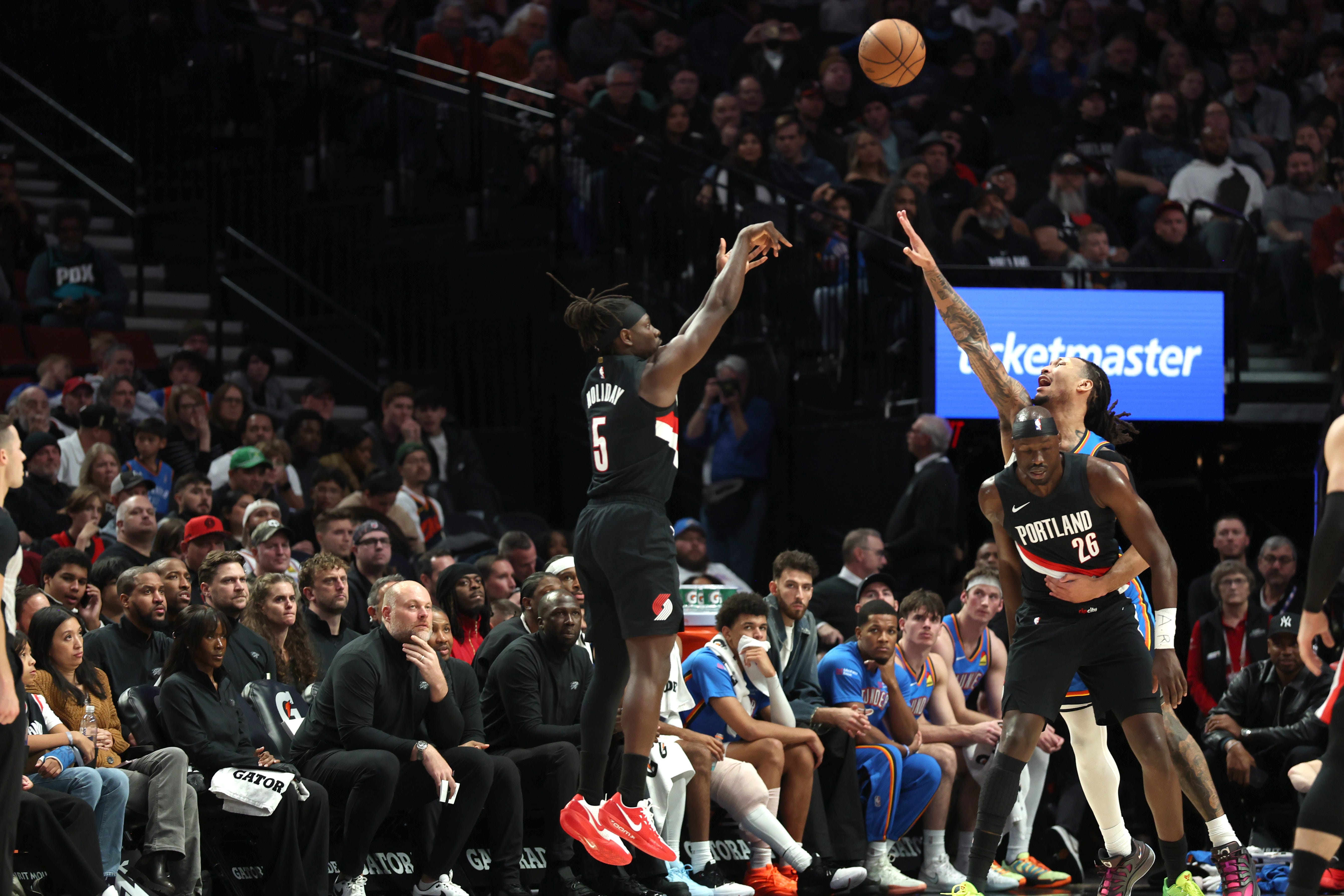 Nov 5, 2025; Portland, Oregon, USA; Portland Trail Blazers guard Jrue Holiday (5) shoots the ball over Oklahoma City Thunder forward Jaylin Williams (6) during the first half at Moda Center. Mandatory Credit: Jaime Valdez-Imagn Images