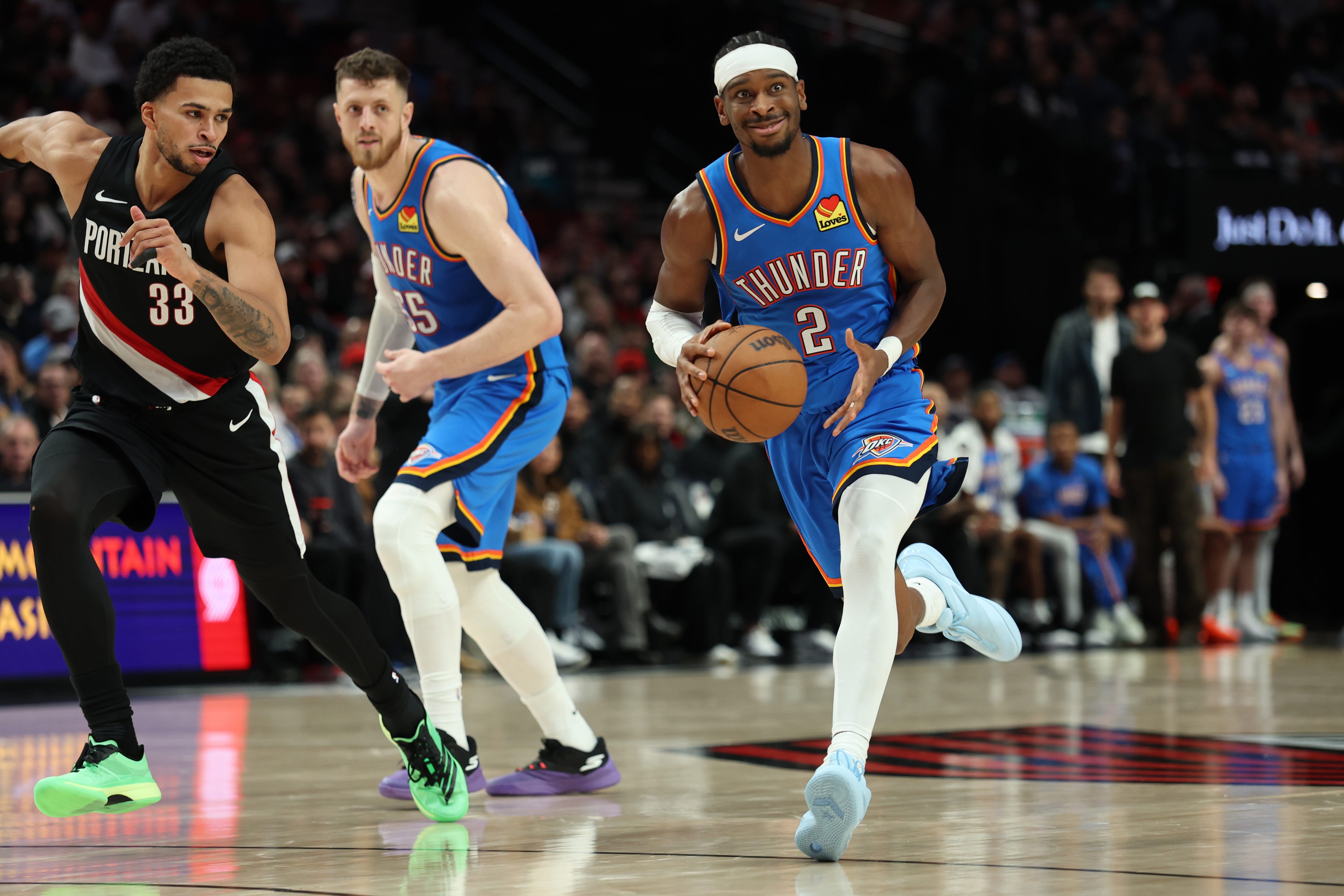 Nov 5, 2025; Portland, Oregon, USA; Oklahoma City Thunder guard Shai Gilgeous-Alexander (2) dribbles the ball past Portland Trail Blazers forward Toumani Camara (33) as teammate Thunder’s center/forward Isaiah Hartenstein (55) watches during the first half at Moda Center. Mandatory Credit: Jaime Valdez-Imagn Images