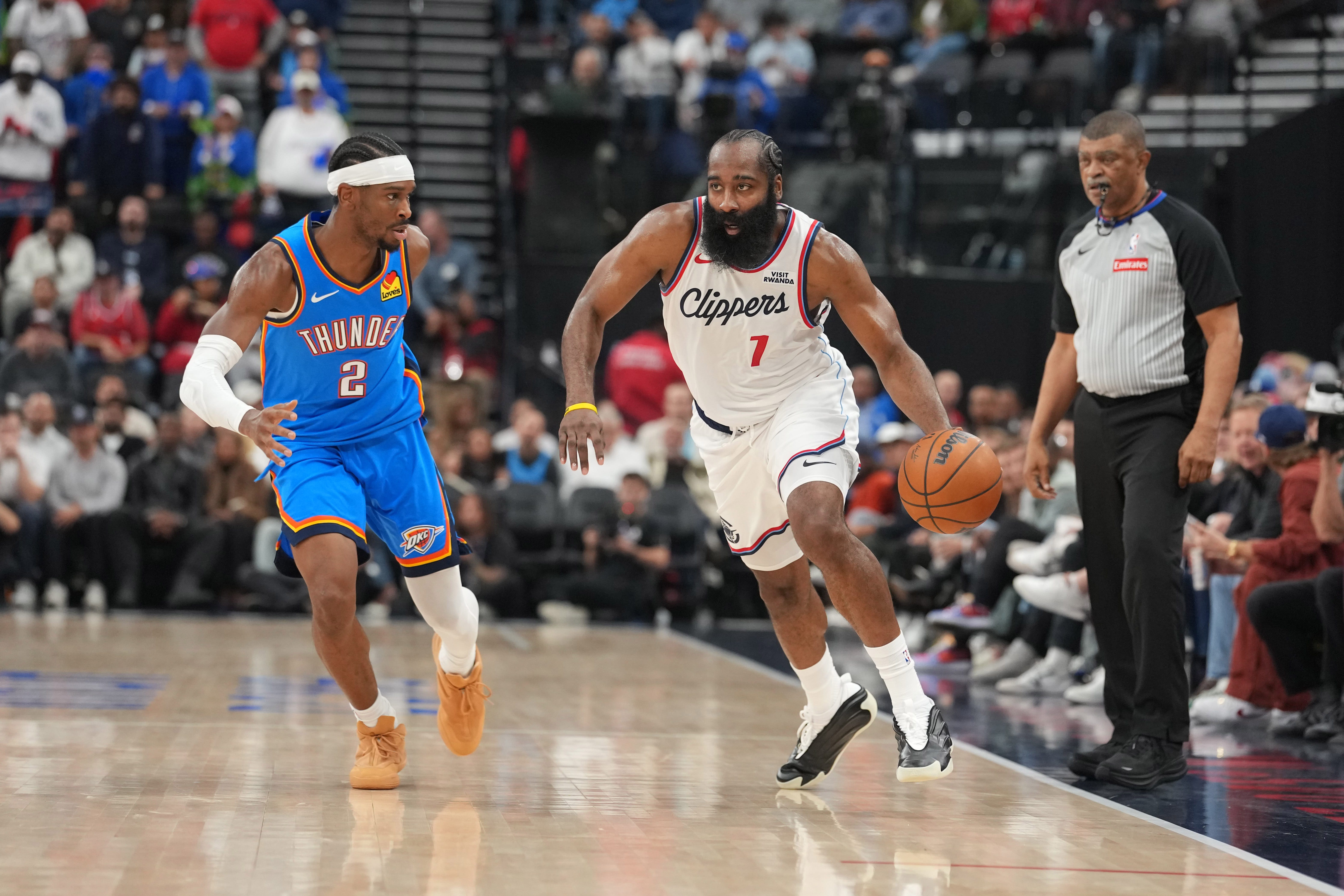 Nov 4, 2025; Inglewood, California, USA; LA Clippers guard James Harden (1) dribbles the ball against Oklahoma City Thunder guard Shai Gilgeous-Alexander (2) in the first half at Intuit Dome. Mandatory Credit: Kirby Lee-Imagn Images