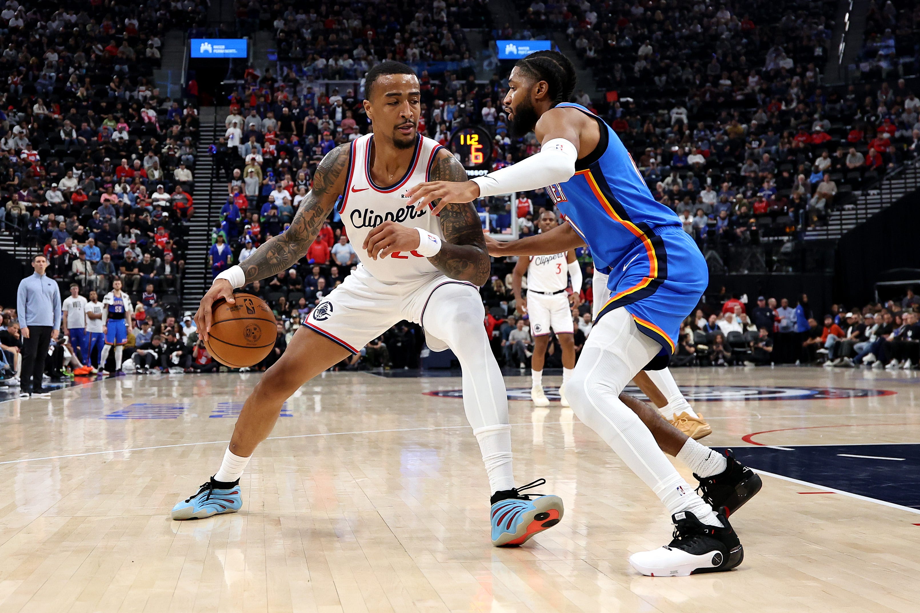 INGLEWOOD, CALIFORNIA - NOVEMBER 04: John Collins #20 of the Los Angeles Clippers dribbles the ball against Isaiah Joe #11 of the Oklahoma City Thunder during the first quarter at Intuit Dome on November 04, 2025 in Inglewood, California. NOTE TO USER: User expressly acknowledges and agrees that, by downloading and or using this photograph, user is consenting to the terms and conditions of the Getty Images License Agreement. (Photo by Luke Hales/Getty Images)