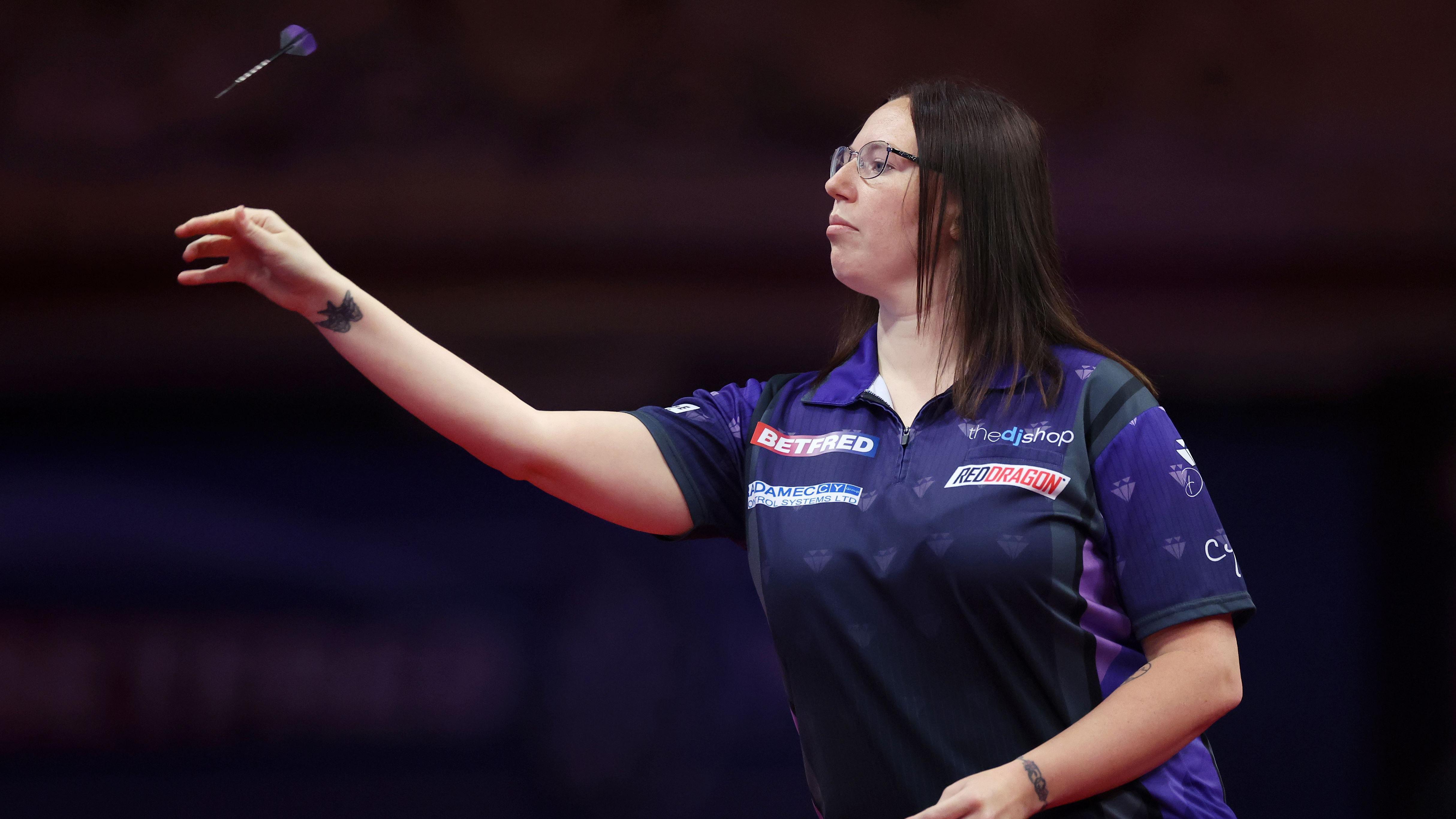 Gemma Hayter wearing purple and throwing a dart on stage.