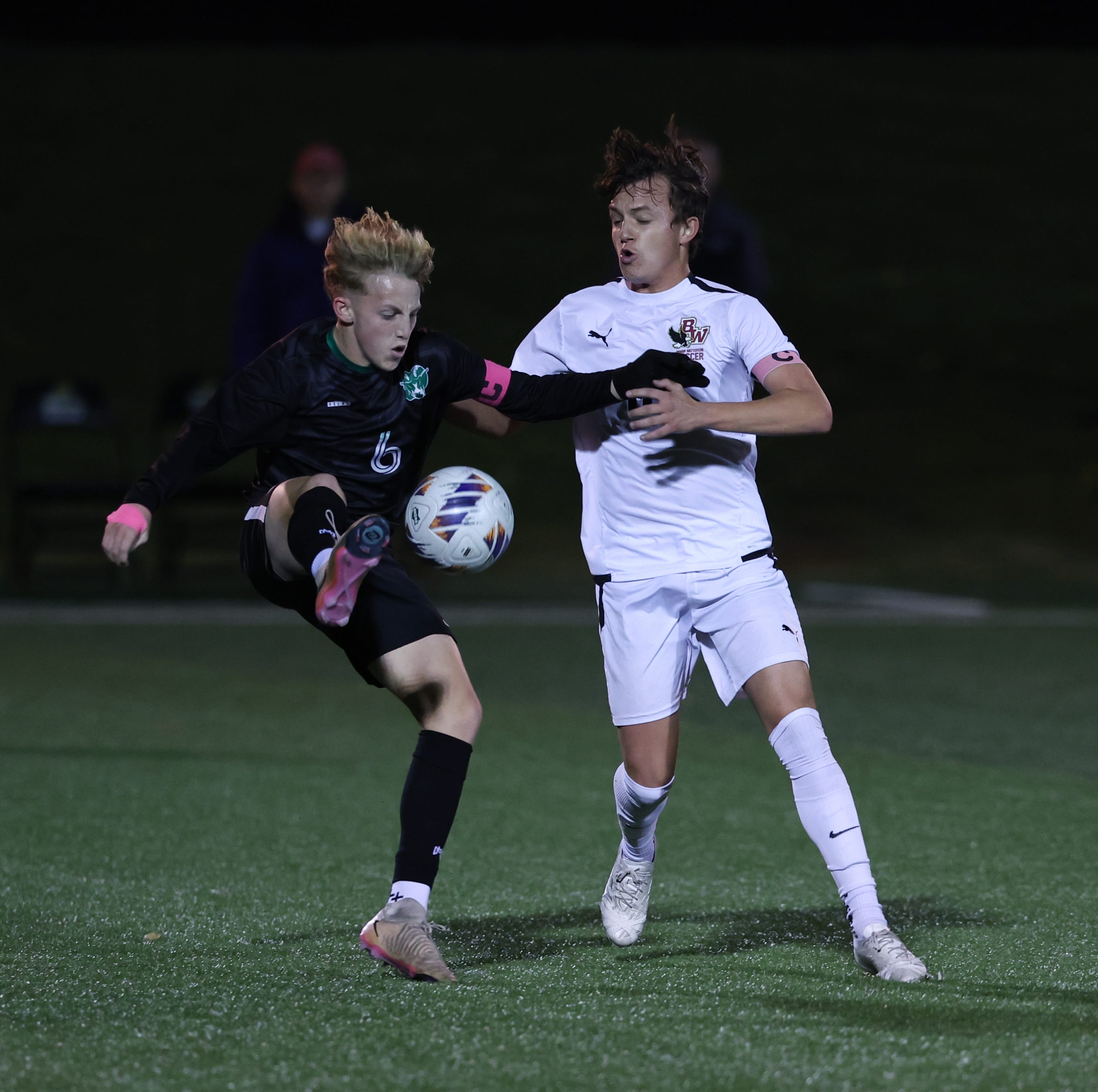 Colt Young (left) of Hamilton Badin kicks the ball in the first half, as Max Meacham of Bishop Watterson tries to steal the ball in the OHSAA DIII state semifinal boys soccer game Wednesday, Nov. 5, 2025. Bishop Watterson won the game 1-0, with 10:39 left in overtime.