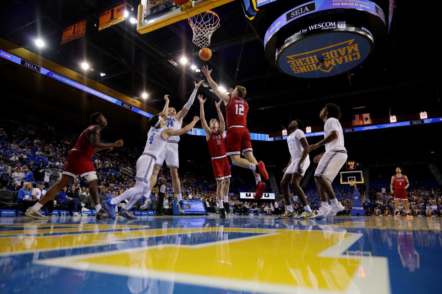 Eastern Washington guard Straton Rogers shoots a layup as UCLA guard Jamar Brown and forward Tyler Bilodeau defend.