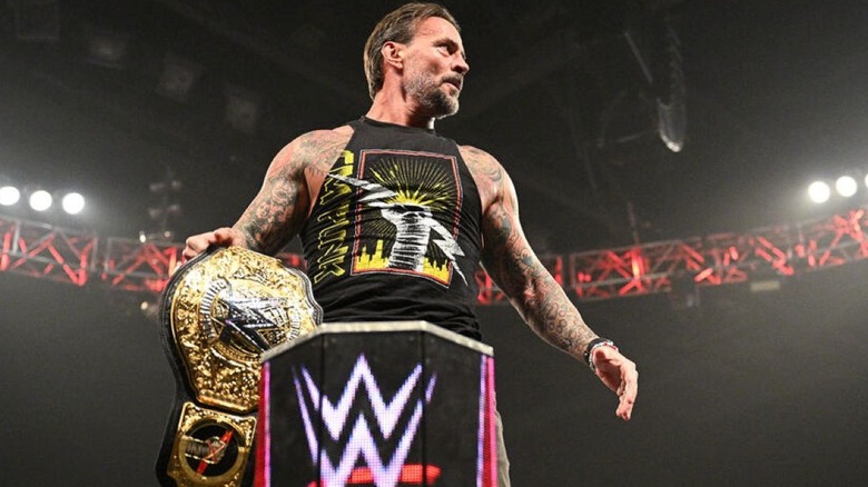 CM Punk holding the world heavyweight title on "WWE Raw"